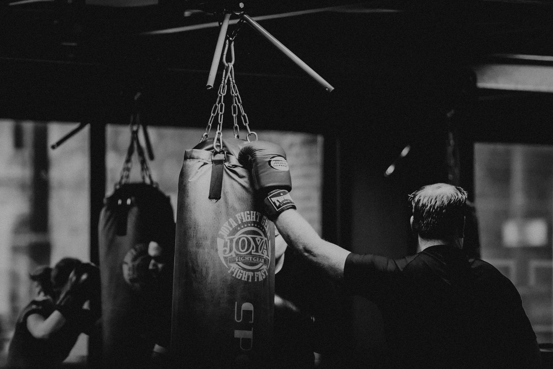 sporter houdt de bokszak vast met zijn bokshandschoen